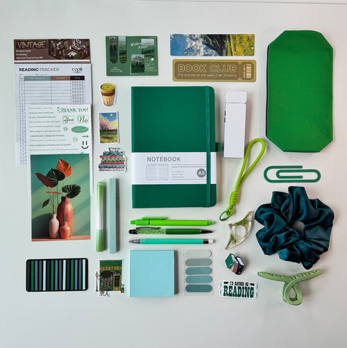 Desk with stationery items including notebooks, pens, and decorative elements.